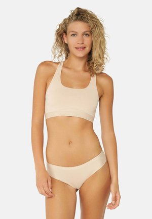 Soutien-gorge de sport beige et bas de bikini assorti en tissu lisse et extensible ; présente un design simple avec des bretelles larges et une couverture modérée.