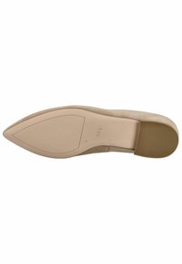 Zapato de tacón stiletto de ante beige con punta afilada. La suela es lisa con un tacón texturizado para mayor agarre, con el nombre de la marca grabado en la parte inferior.