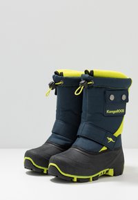 Marineblaue Schneestiefel mit gelben Akzenten, Gummisohlen, Obermaterial aus Stoff, verstellbarem Schaft und seitlichem Branding. Entwickelt für winterliche Bedingungen.
