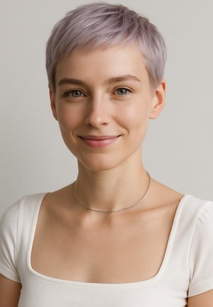 Silberne Kettenhalskette an einer Person mit einem weißen Oberteil mit quadratischem Ausschnitt, kurzen hellen Haaren, neutralem Hintergrund.