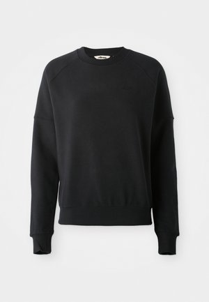 Juodas sportinis megztinis su raižyta apykakle, raglano rankovėmis ir šiek tiek trumpesne forma. Yra subtilus logotipas medžiagoje. Minkšta tekstūra.