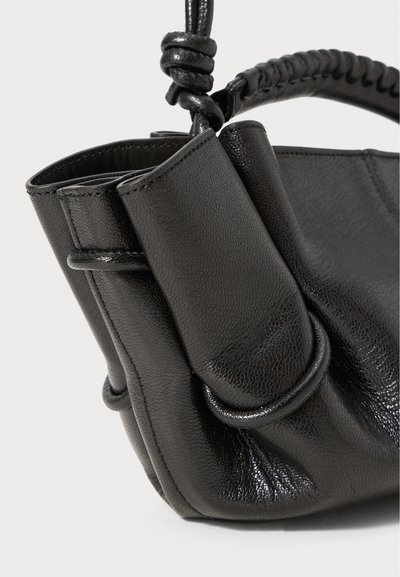 Black leather handbag with a textured finish, featuring a braided handle and side pockets, showcasing a compact and structured shape.