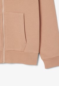Sudadera de color rosa claro con cremallera, de textura suave, que presenta bolsillos frontales y puños acanalados en las mangas y el dobladillo.