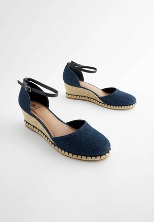 Farmer denim wedges, kerek orrú, fekete bokapánttal, juta borítású sarokkal és sima barnás belső résszel. A talpon varrás található.