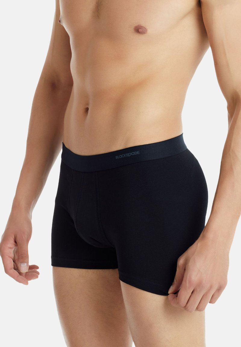 Černé boxerky v jednolité černé barvě s hladkým pasem, na kterém je uvedeno jméno značky "BLACKSPADE". Materiál je měkký a elastický.