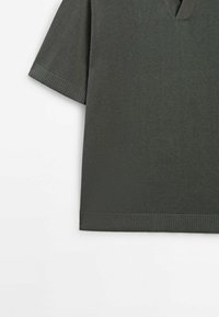 Polo à manches courtes en maille gris foncé avec poignets et ourlet côtelés, présenté sur fond blanc.