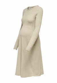 Beige zwangerschapsjurk van zacht breiwerk, met ribbeltextuur, lange mouwen en een uitlopende rok voor comfortabel en passend draaggemak.