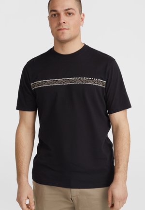 Camiseta de algodón negra con cuello redondo y mangas cortas, que presenta una franja horizontal de color beige con un patrón en el pecho.