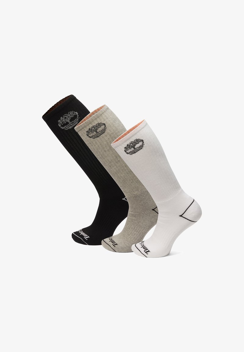 Tre par knæhøje sokker i sort, grå og hvid, med ribbet tekstur og logo-detalje nær toppen.