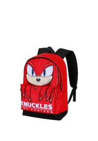 Mochila roja con un gráfico de Knuckles el Equidna en la parte frontal, fondo negro, dos correas para los hombros y un bolsillo delantero.