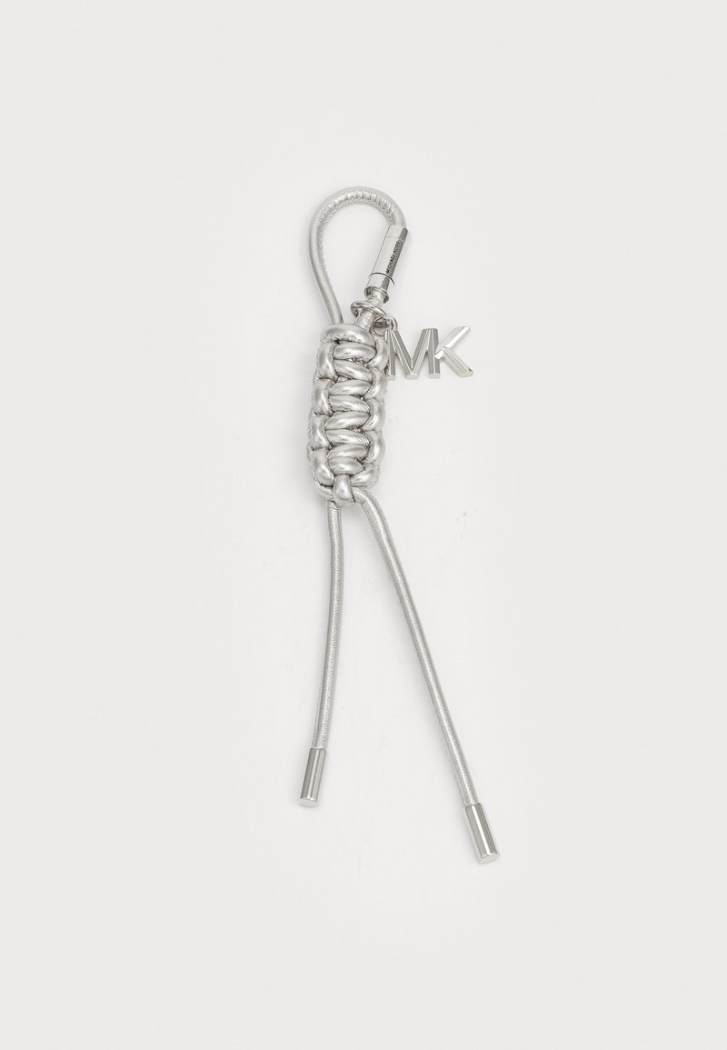 Porte-clés en argent avec un design tressé. Présente une boucle, deux brins métalliques et un charme "MK" attaché. Texture lisse avec une finition brillante.