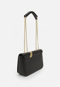 Borsa a mano in pelle nera con una fascia decorativa dorata, caratterizzata da una forma strutturata e una doppia tracolla a catena per il trasporto. Texture liscia.