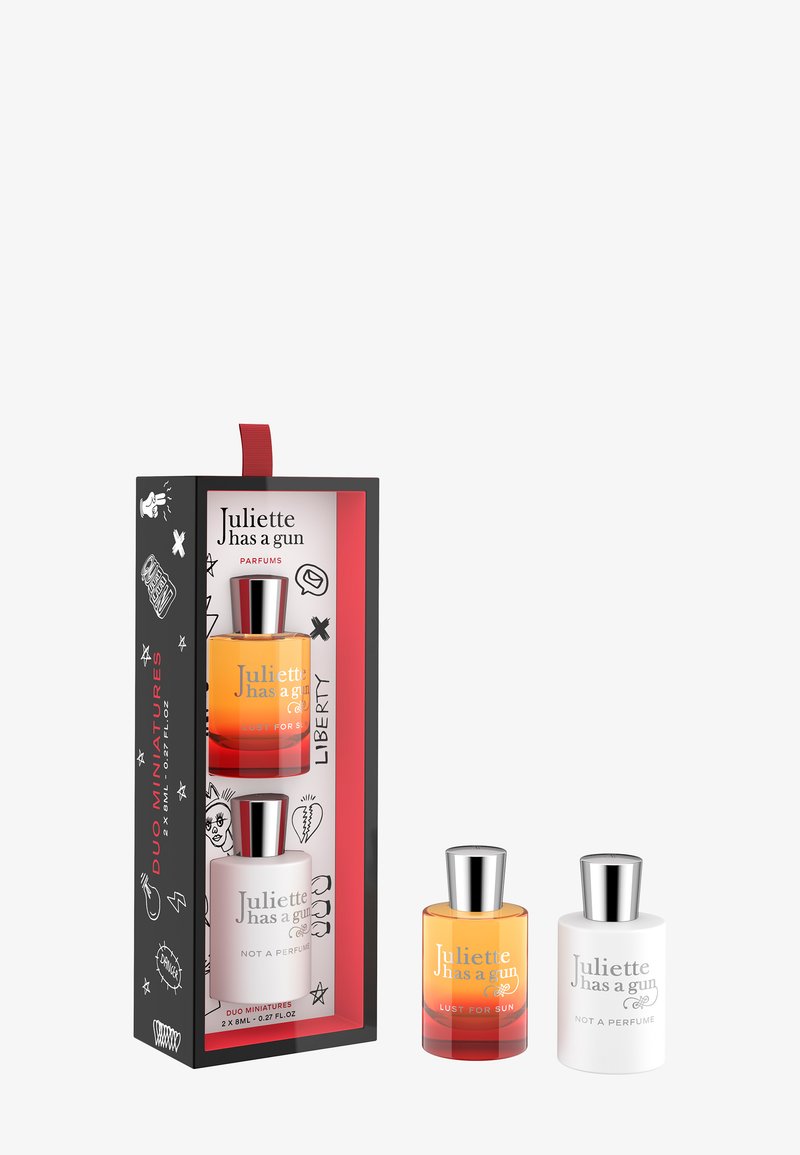 Due bottiglie mini di profumo in una scatola nera con accenti rossi. Include una bottiglia con liquido ambrato (Lust for Sun) e una bottiglia bianca (Not a Perfume).
