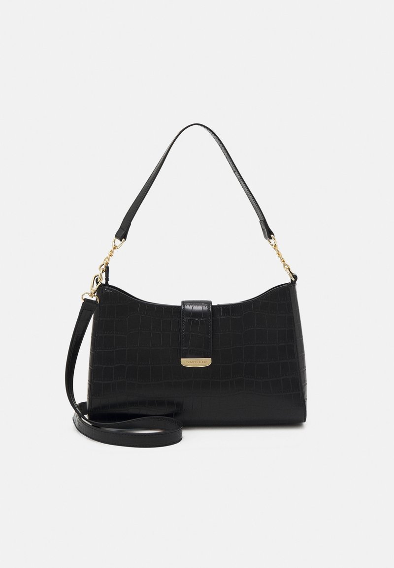 Sac à main en cuir synthétique noir effet crocodile avec poignée supérieure, bandoulière amovible et ferrures dorées sur fond clair.