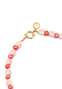 Collier à perles chunky avec des perles en forme de goutte d'eau roses et des accents rouges lisses, doté d'un fermoir doré et d'une étiquette de logo.