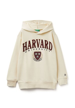 Sudadera color crema con un gran texto en color marrón "HARVARD", logo de la universidad, bolsillo tipo canguro en el frente, y puños y dobladillo acanalados.