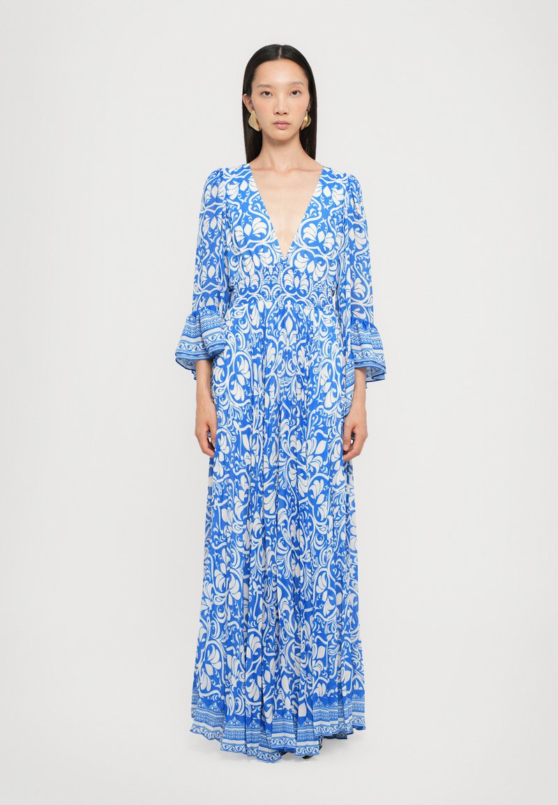 Abito maxi con scollatura a V profonda, motivo floreale blu e bianco, maniche lunghe a campana e un tessuto fluido e testurizzato. Dettagli decorativi all'orlo.
