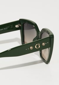 Guess Occhiali da sole - shiny dark green/gradient smoke