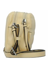 Bolso cruzado de cuero color crema con un diseño acolchado, cierre de doble cremallera y correa ajustable. Acentos de hardware en plateado.