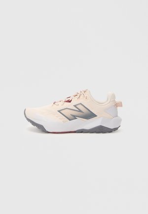 Lys beige atletisk sneaker med grå såle, mørkegrå "N"-logo og maroon-detaljer, sett fra venstre side på hvit bakgrunn.