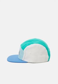 Colorful cap featuring a blue brim, turquoise and white panels, and a stitched label on the front. Crafted from fabric with a smooth texture.