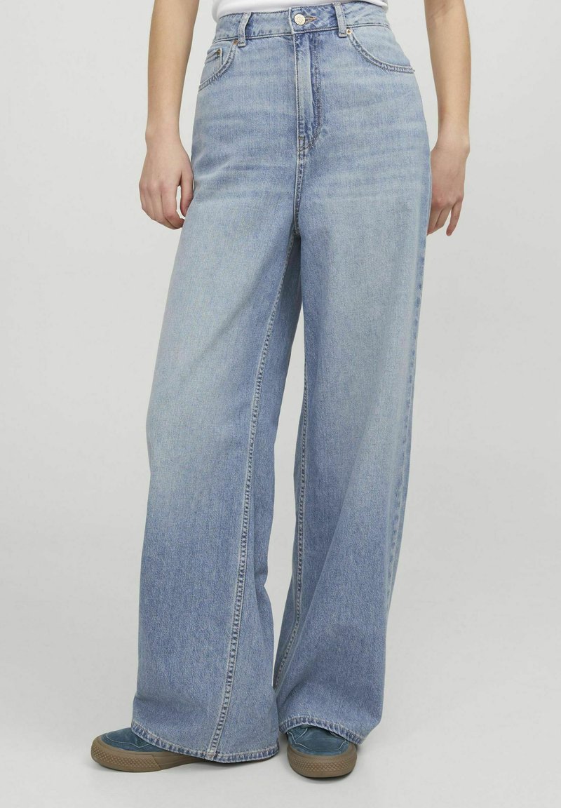 Ljusblå vida denimjeans med hög midja, bälteshällor och framfickor. Avslutade med synlig sömnad och en avslappnad passform.