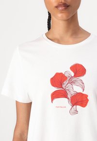 Witte katoenen t-shirt met een rood bloemendessin met vloeiende lijnen en een klein logo met de tekst "TOM TAILOR" onderaan.