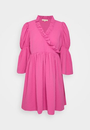 Robe rose vif texturée avec devant croisé, encolure en V volantée, et manches trois-quarts bouffantes finissant par des poignets évasés.