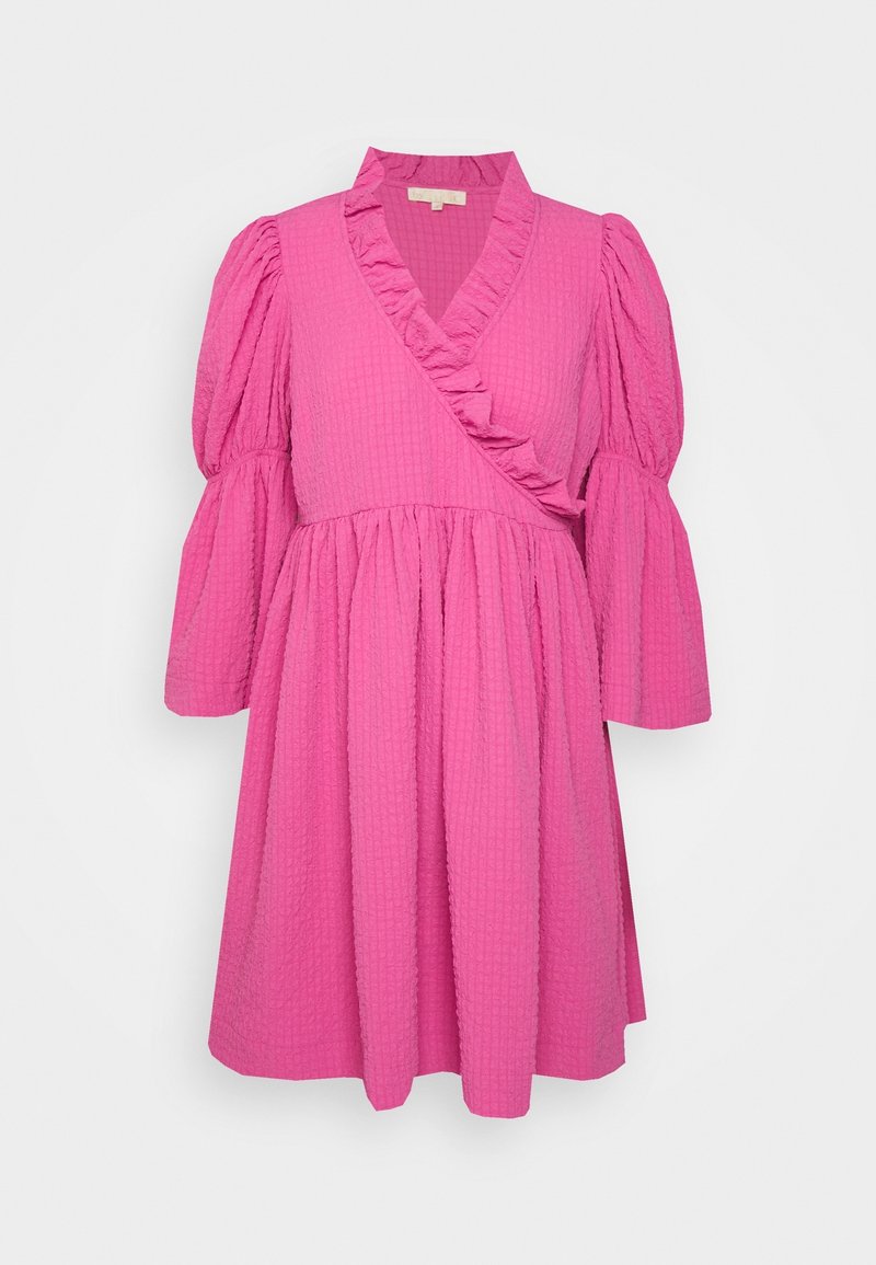Robe rose vif texturée avec devant croisé, encolure en V volantée, et manches trois-quarts bouffantes finissant par des poignets évasés.