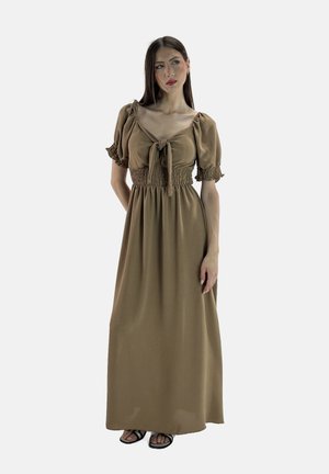 Bruine maxi-jurk met korte puffmouwen, gerimpelde taille en een strikdetail bij de hals. De stof lijkt licht en vloeiend.
