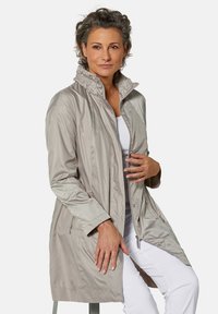 Helles grauer, langer Regenmantel aus glänzendem Stoff mit hohem Kragen, Reißverschluss vorne und Seitentaschen. Glatte Textur, gerader Schnitt.