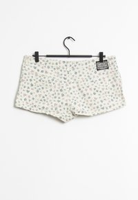Shorts in cotone con stampa floreale color crema, caratterizzati da piccoli fiori blu e rosa, due tasche posteriori e un'etichetta con il marchio sulla cintura.