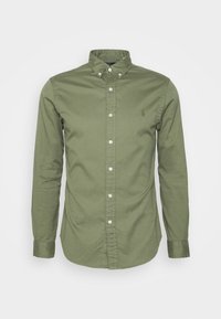 Olivgrön långärmad skjorta i bomull, med knäppning vid kragen, framsidan har en knappslutning, och den har en liten broderad logotyp på bröstet.