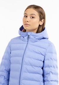 Giacca puffer azzurro chiaro con design a righe orizzontali, cappuccio e logo a forma di cuore dorato sul petto. Chiusura con zip dotata di un tirante a forma di cuore.