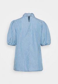 Ljusblå denimtopp med korta puffärmar, hög halsringning och en nyckelhålsdetalj på baksidan. Har en lös passform och en enkel textur.