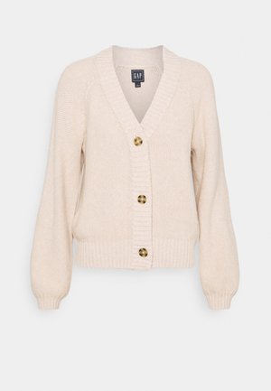 Cardigan en maille couleur crème avec col en V, poignets et ourlet côtelés, et trois boutons en écaille de tortue sur le devant.