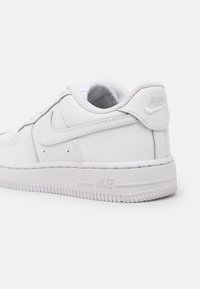 Białe sneakersy Nike Air Force 1 z gładkiej skóry, zaokrąglonym noskiem, wyściełanym kołnierzem oraz teksturowaną gumową podeszwą z logo.