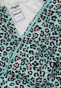 Padded children's jacket in teal with black and pink leopard print. Features a zip closure, ruffled edges, and a soft white interior lining.