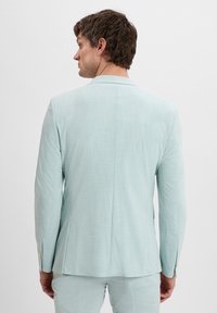 Helle blaue Anzugjacke, strukturierter Stoff, einzelner Rückenvent, lange Ärmel und dezente Steppdetails an den Manschetten. Minimalistisches Design.