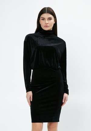 Robe en velours noir avec un col montant, des manches longues et une silhouette ajustée. Texture lisse et design à longueur de genoux.