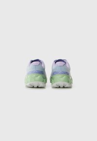 Sneakers con tomaia in mesh, tonalità gradienti di viola e blu, accento verde sul tallone e suola grigia texturizzata.