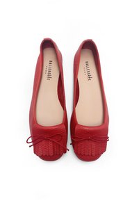 Bailarinas de cuero rojo con superficie texturizada, detalle de lazo atado en la punta y plantilla acolchada. Forro interior suave, forma redondeada.