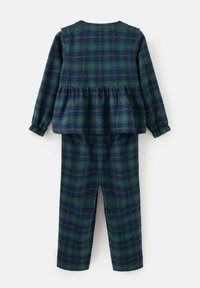 Ensemble à carreaux verts composé d'un haut peplum à manches longues et avec des poignets élastiques, associé à un pantalon droit assorti.