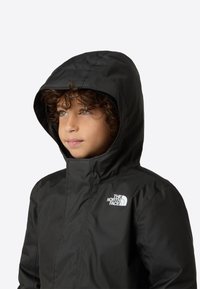 Černá zimní bunda s kapucí, vyrobená z hladkého materiálu. Na levé hrudi se nachází bílé logo značky The North Face.