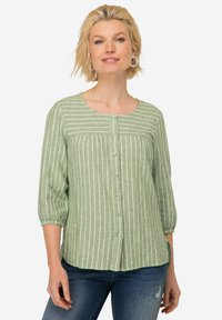 Blusa de rayas verdes con mangas tres cuartos, botones al frente, escote redondeado y tela texturizada. Acentuada con rayas verticales blancas.
