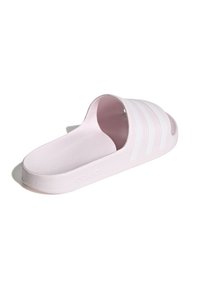 Světlé růžové pantofle na klínku se třemi bílými pruhy na svrchní části. Vyrobené z texturovaného materiálu s plochou podrážkou a vypouklým logem na boku.