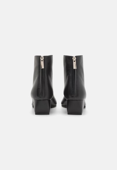 Černé kožené kotníkové boty se čtvercovými podpatky, se zadním zipem a hladkým povrchem. Design je elegantní a minimalistický.