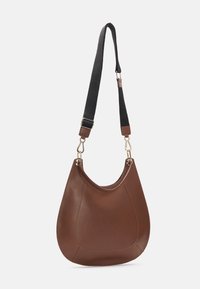 Ruskea nahkainen hobo-kassi, jossa on sileä pinta, kaareva muoto ja irrotettava mustasta kankaasta valmistettu hihna, jossa on kullanväriset yksityiskohdat.