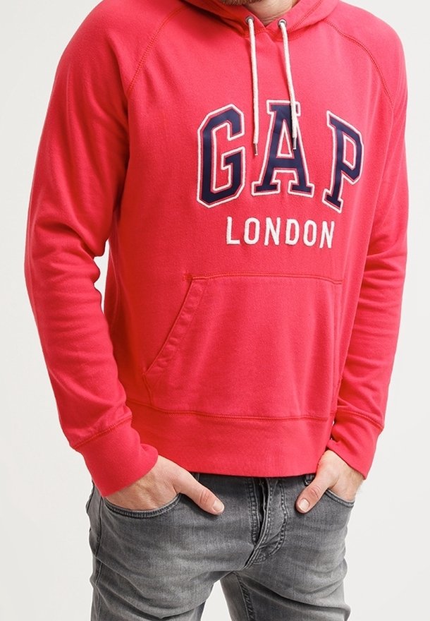 Sweat à capuche rouge avec cordons blancs et poche avant. Comprend un grand logo "GAP" en bleu avec "LONDON" en dessous. Tissu doux, coupe décontractée.