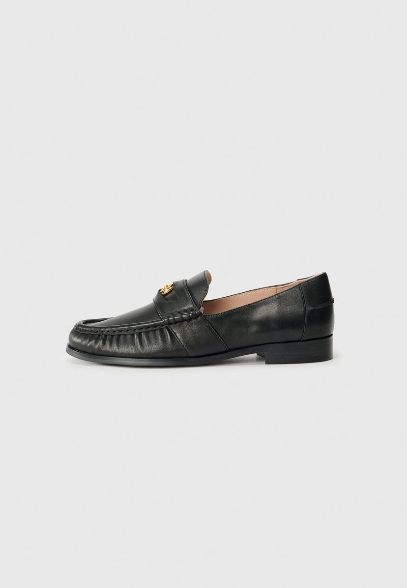Black leather loafer with a rounded toe, featuring a stitched detail along the front and a small gold accent on the upper. Flat sole.